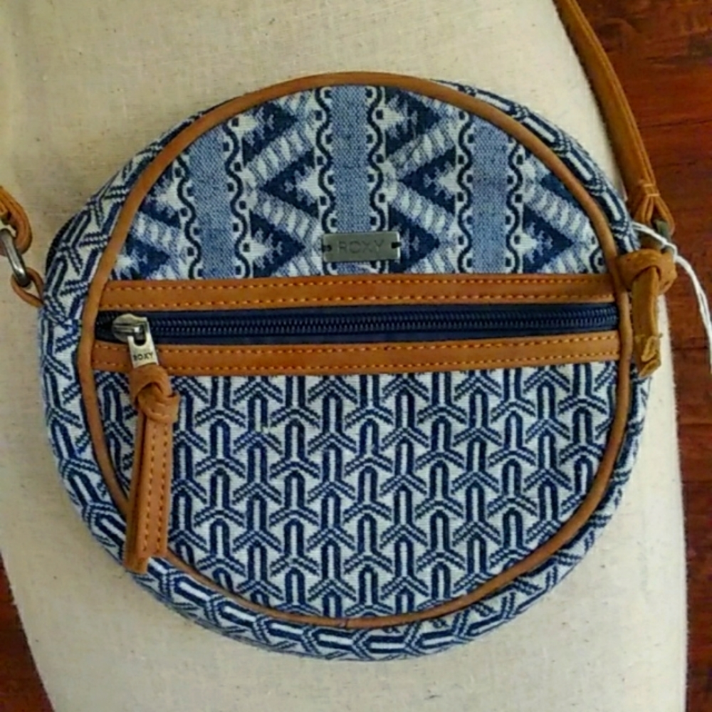 NWT ROXY ROUND CROSSBODY PURSE IN BLUE/IVORY TRIBAL PRINT. LT BROWN TRIM